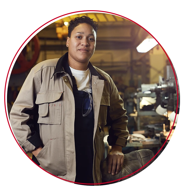 Female manufacturing worker posing in front of work area.